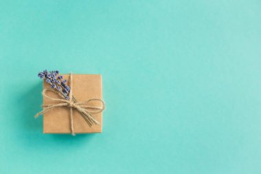 Turkuaz arka planda küçük lavanta desenli el işi hediye kutusu. Tatil çevre dostu kavram. Metin için yer.