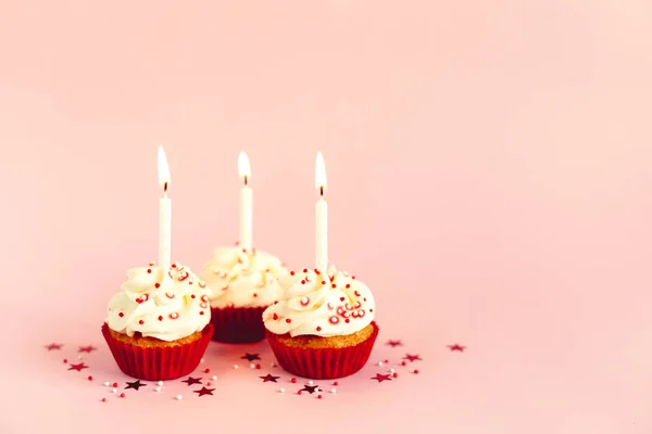 Cupcakes de cumpleaños con glaseado de crema de mantequilla y vela sobre fondo pastel rosa . —  Fotos de Stock