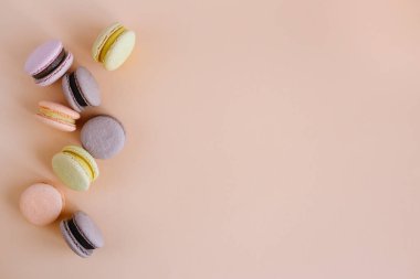 Şeftalili pastel arka planda lezzetli Fransız kurabiyeleri. Düz yatıyordu.