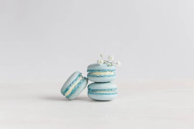 Beyaz ahşap arka planda küçük çiçekli lezzetli mavi Fransız kurabiyeleri. Metin için yer.