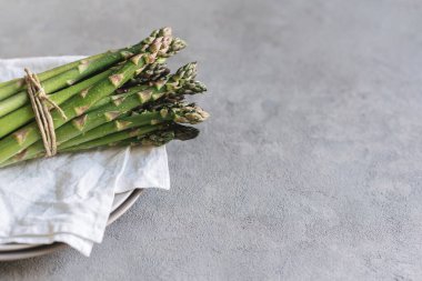 Gri arka planda bir sürü taze kuşkonmaz. Metin için yer.