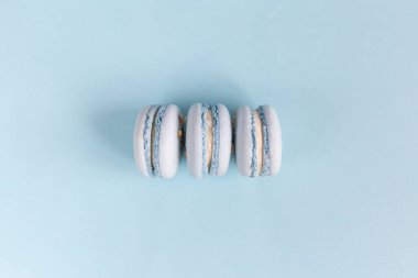 Açık mavi pastel arka planda lezzetli Fransız badem kurabiyeleri. Düz yatıyordu. Metin için yer.