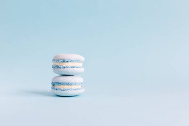 Açık mavi pastel arka planda lezzetli Fransız badem kurabiyeleri. Metin için yer.