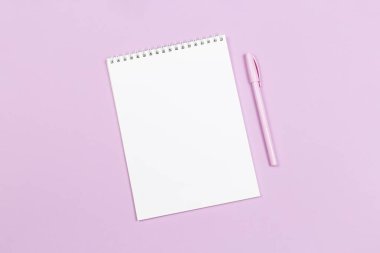 Boş sayfası ve menekşe rengi pastel arka planı olan bir defter. Düz yatıyordu. Metin için yer. 
