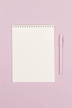 Boş sayfası ve menekşe rengi pastel arka planı olan bir defter. Düz yatıyordu. Metin için yer. 