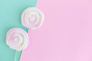 Pembe ve turkuaz arka planda iki krema. Bayram tebrik kartı veya geçmiş konsepti. Düz yatıyordu. Metin için yer.