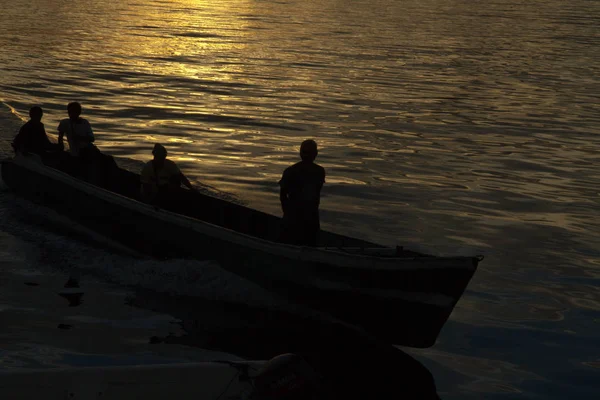 The fisherman are cruising to the ocean for fishing on beautiful golden sunrise