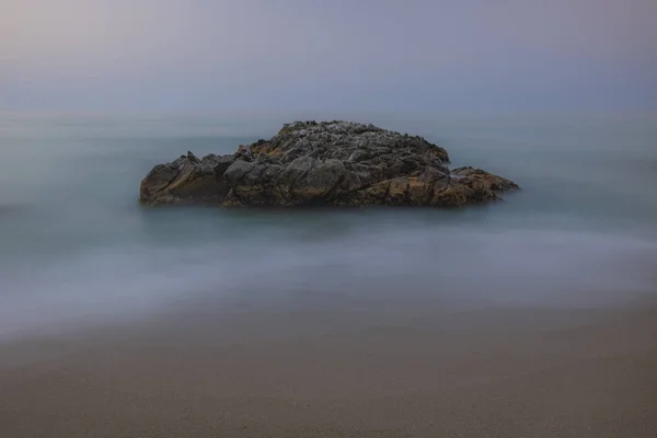 Velocidade lenta do obturador fotografando a água em torno de um formato de rocha — Fotografia de Stock