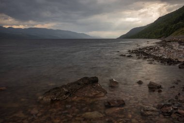 Loch Ness, a large, deep, freshwater loch in the Scottish Highlands  best known for alleged sightings of the Loch Ness Monster, on a stormy day.  clipart