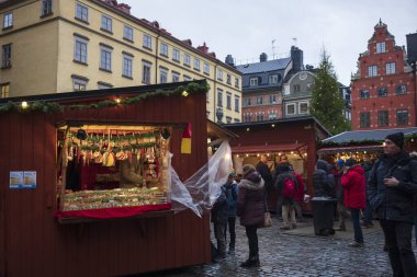 Stockholm, İsveç / 11 Aralık 2019: Müşteriler İsveç 'in eski Stockholm kasabası Gamla stan' daki bir Noel köyünden eşya satın alıyorlar. 