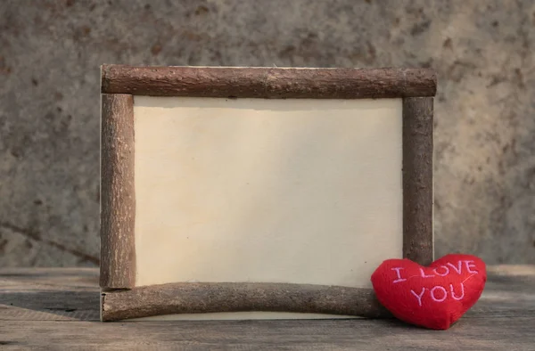 Marco de madera con corazón en la mesa de madera — Foto de Stock