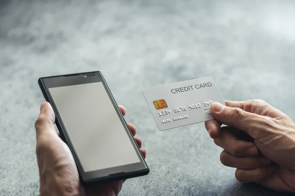 El ele tutuşan kredi kartı ve akıllı telefon. E-ticaret ya da e-ticaret çevrimiçi alışveriş ve ödeme. Siber uzayda ticaret için dijital para transferi. İş ve finans kavramı.