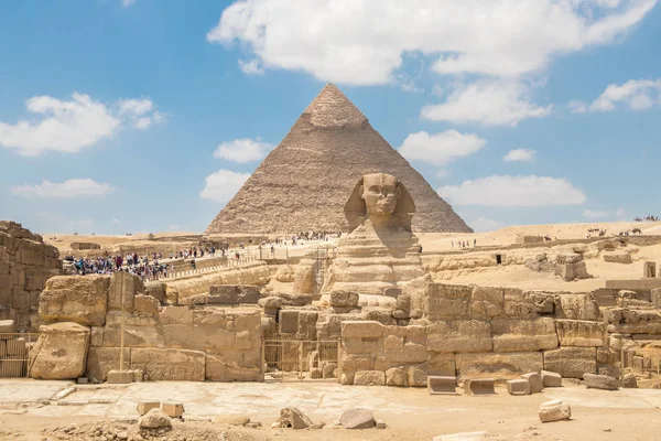 El monumento de la Esfinge con el cuerpo de un león y la cabeza de un faraón en la pirámide de fondo de Chephren, Egipto —  Fotos de Stock