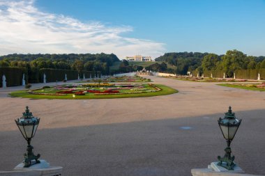 Viyana, Avusturya - 3 Eylül 2019: Schonbrunn Sarayı ve renkli çiçekli bahçe. Fotoğraf sabah erken saatlerde çekildi. Güneşin doğuşu sayesinde daha sıcak renkler. Viyana, Avusturya