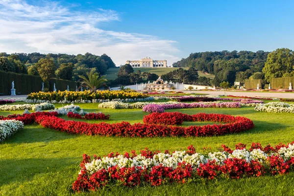 Vista sobre Schonbrunn Palace e jardim com flores coloridas, bandeira austríaca feita de flores — Fotografia de Stock