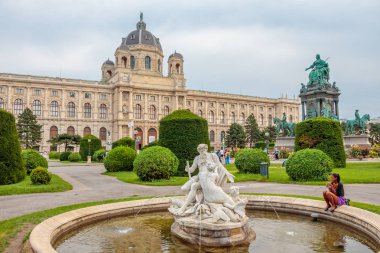 Kız Avusturya, Viyana 'daki Doğal Tarih Müzesi' nin önündeki çeşmenin yanında oturuyor.