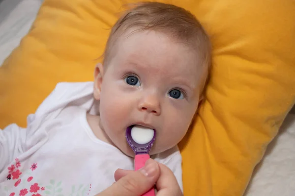 Mother feeding her baby girl with a spoon. Mother giving food to her four-month old baby. — Stock Image Mother Feeding Her Baby Girl Spoon Mother Giving Food Her Royalty Free Stock Photos