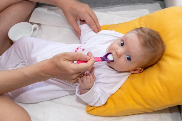 Mother feeding her baby girl with a spoon. Mother giving food to her four-month old baby. — Stock Image Mother Feeding Her Baby Girl Spoon Mother Giving Food Her Stock Image