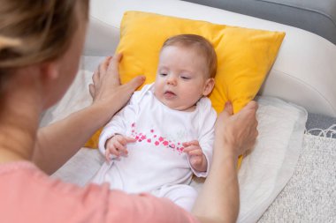 Uykulu bebek evde yumuşak bir yastığın üzerinde yatıyor. Bebek daha dört aylık..