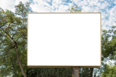 Billboard tuval beyazı şehirde, arka planda ağaçlar ve bulutlar var.