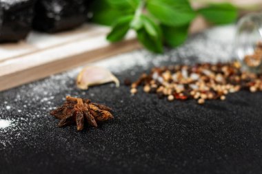 Kesme tahtasının üzerinde taze siyah çavdar ekmeği ve siyah ahşap bir masaya un serpiştirilmiş baharatlar.