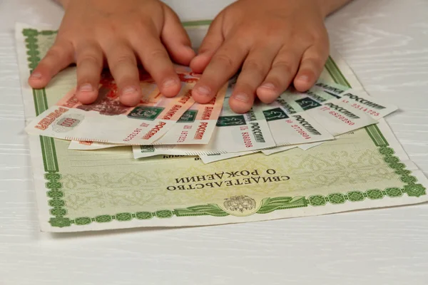 dokümanlar ve kağıt para masanın üzerinde doğum belgesi var.