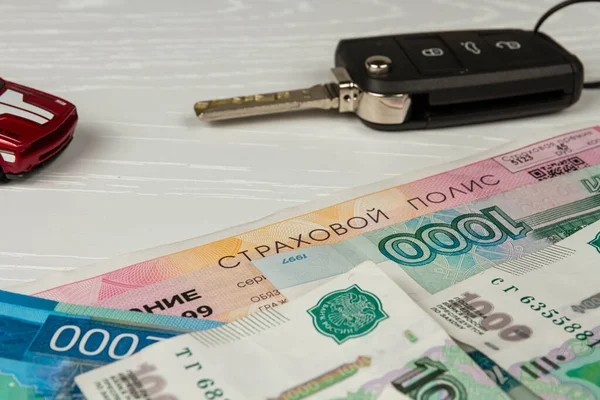 Sigorta poliçesi ve para beyaz ahşap masa yazılı sigorta poliçesine yatar.