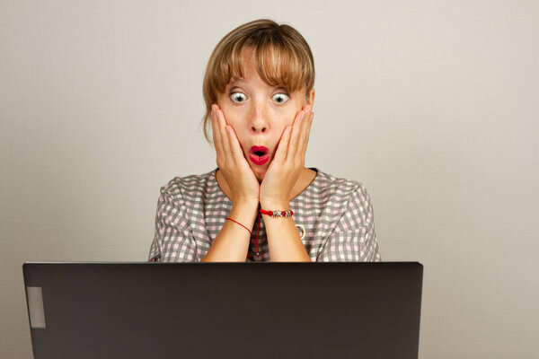 beautiful young girl was very surprised working in the office at the computer