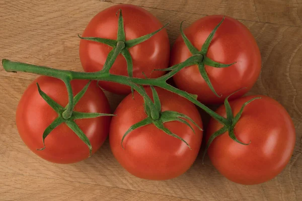 Rama Con Cinco Tomates Una Tabla Madera —  Fotos de Stock