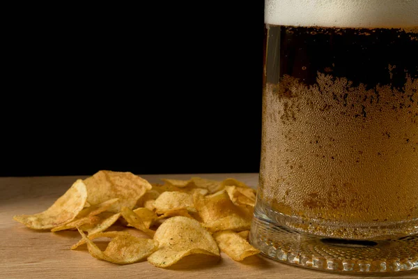 Copo Com Cerveja Batatas Fritas Uma Tábua Madeira Fundo Preto — Fotografia de Stock