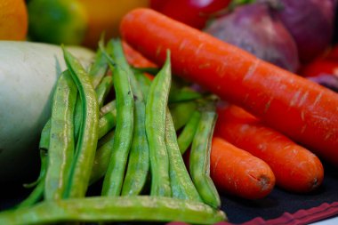 Siyah arka planda taze karışık sebze domatesleri, havuç, yeşil biber ve limon. Taze renkli sebzeler.  