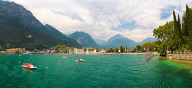Şehir Riva del Garda yakınlarındaki zümrüt gölü Lago di Garda Kıyıları, dağlar (alpler) ve arka planda bulutlu gökyüzü
