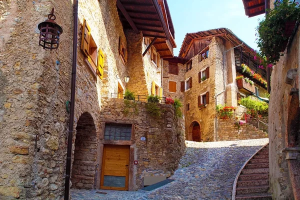 Canale di Tenno - İtalya'da güzel ortaçağ köyü, Göl Lago di Garda, pencerelerde taş duvarlar ve çiçekler ile dağlarda hisoric köy, dar arnavut kaldırımlı sokaklar