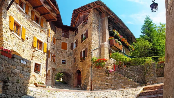 Canale di Tenno - İtalya'da güzel ortaçağ köyü, Göl Lago di Garda, pencerelerde taş duvarlar ve çiçekler ile dağlarda hisoric köy, dar arnavut kaldırımlı sokaklar