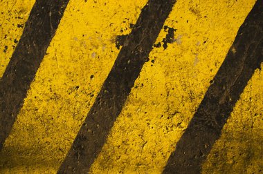 Textured concrete slab painted in yellow and black stripes. clipart