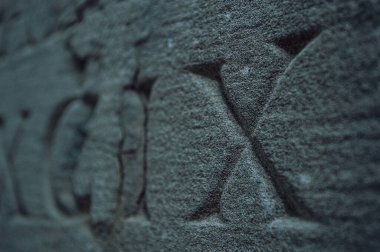 Eski Roma rakamları bir doku taşına kazınmış. Yakın plan.