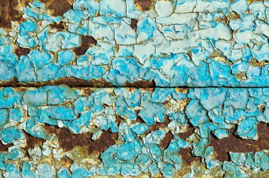 Paslı metalin arka planında boyaları yakın çekimde soyulmuş.