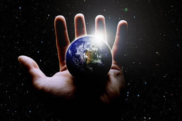 A mans hand holds the globe close up