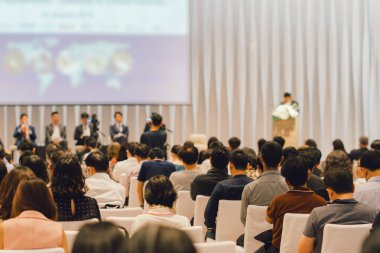 Sahnede, iş ve eğitim yatırım kavramı hakkında hoparlörlere sahip konferans salonu veya seminer toplantı seyirci görünümünde arka