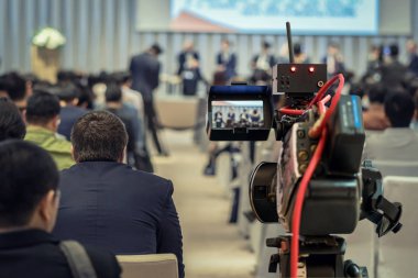 Closeup Video konferans salonu veya seminer toplantı, olay ve seminer kavramı seyirci arkadan görünüm üzerinden Sahne Alanı'nda hoparlör resmi takım elbise ile kayıt
