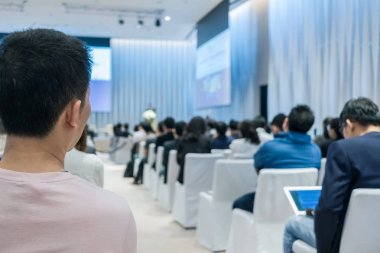 Sahnede, iş ve eğitim yatırım kavramı hakkında hoparlörlere sahip konferans salonu veya seminer toplantı seyirci görünümünde arka