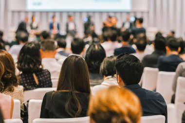 Sahnede, iş ve eğitim yatırım kavramı hakkında hoparlörlere sahip konferans salonu veya seminer toplantı seyirci görünümünde arka