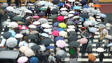 Tokyo, Japonya - Ekim 2017: Tanımsız Japon insanlar kalabalık yürüyüş haçlar için 28 Ekim 2017 Jr Shinjuku İstasyonu Tokyo, Japonya'da binalar arasında yağmur ile sokak.