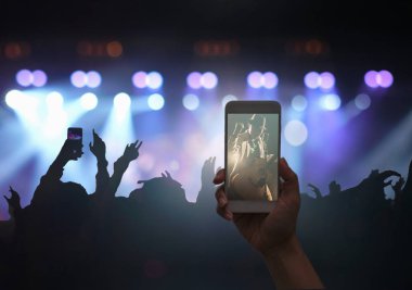 Mobil akıllı tutan el video kayıt alarak telefon ya da konser akışı kalabalık süper star songer ve müzik fanclub eylemle gösteri el, müzikal ve konser kavramı siluetleri ile yaşamak