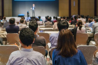 Arka tarafında oturan ve düşük ışık konferans salonu, olay ve seminer kavramı sahnede speackers dinleme kitlelere