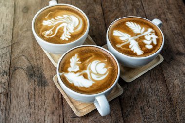 Hangi ahşap masa, içki ve kahve dükkanı kavramı latte sanat ve capuchino ABD oluşur en iyi kahve fincanı görünümünü ayarlama