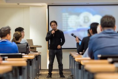 Sahne Alanı'ndaki iş veya eğitim seminer sunum ekran üzerinde düşük ışıkta rahat takım elbise ile Asya hoparlör