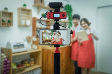 Closeup akıllı cep telefonu alarak yaşamak, mutlu Asya sevgilisi ya da çift kamera için fotoğrafçı ya da Video ve Live Streaming kavram mutfak Oda pişirme