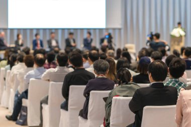Sahnede, iş ve eğitim yatırım kavramı hakkında hoparlörlere sahip konferans salonu veya seminer toplantı seyirci görünümünde arka