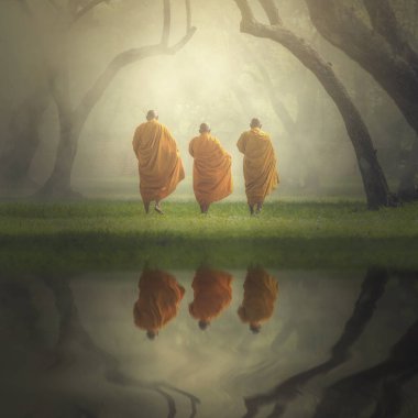 Fantastic scene of asian three monks hiking with reflection the lake in deep forest , Buddha Religion concept clipart